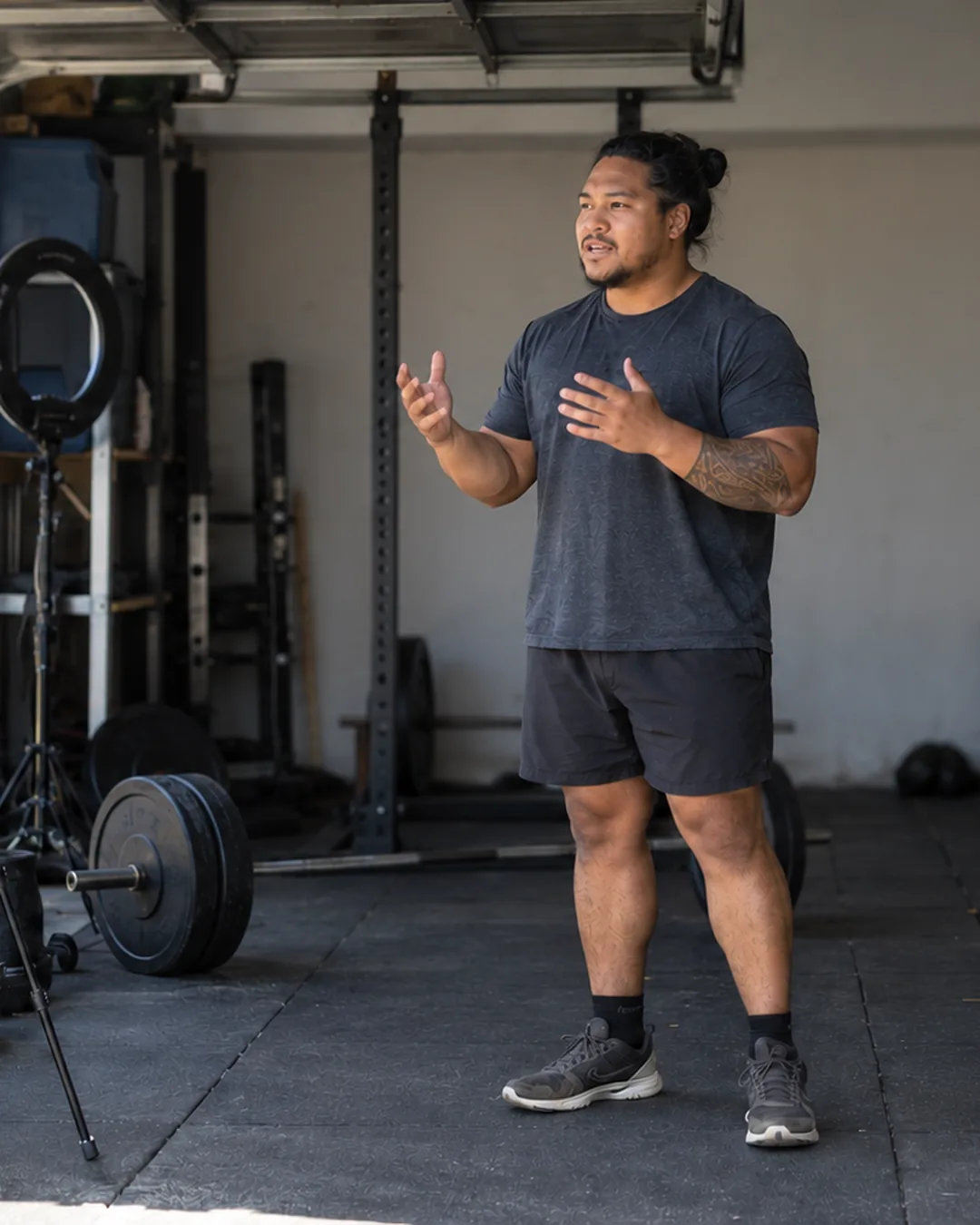 A fitness creator tries different openings to a camera in his garage gym.