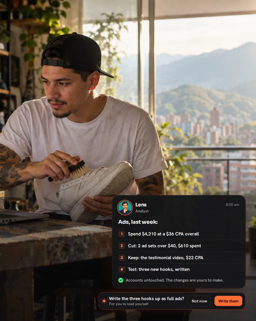 A young sneaker-cleaning business owner at a workbench with a brush in hand, glancing at a laptop on a Monday morning.