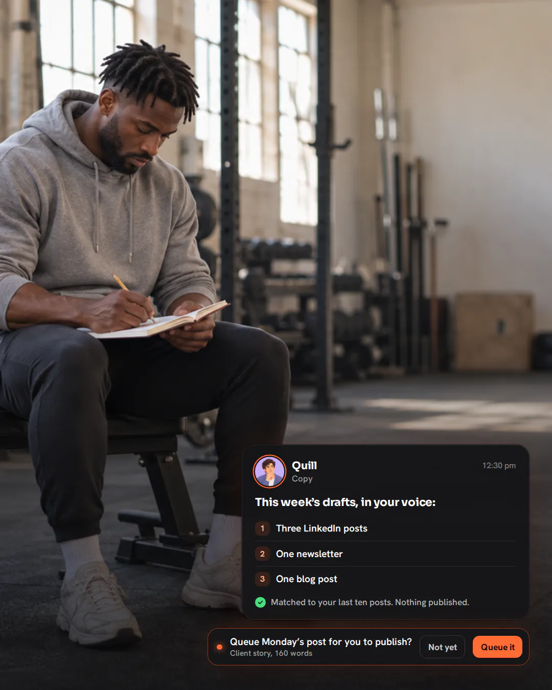 A strength coach sitting on a weight bench in an empty gym at midday, writing in a notebook on his knee.