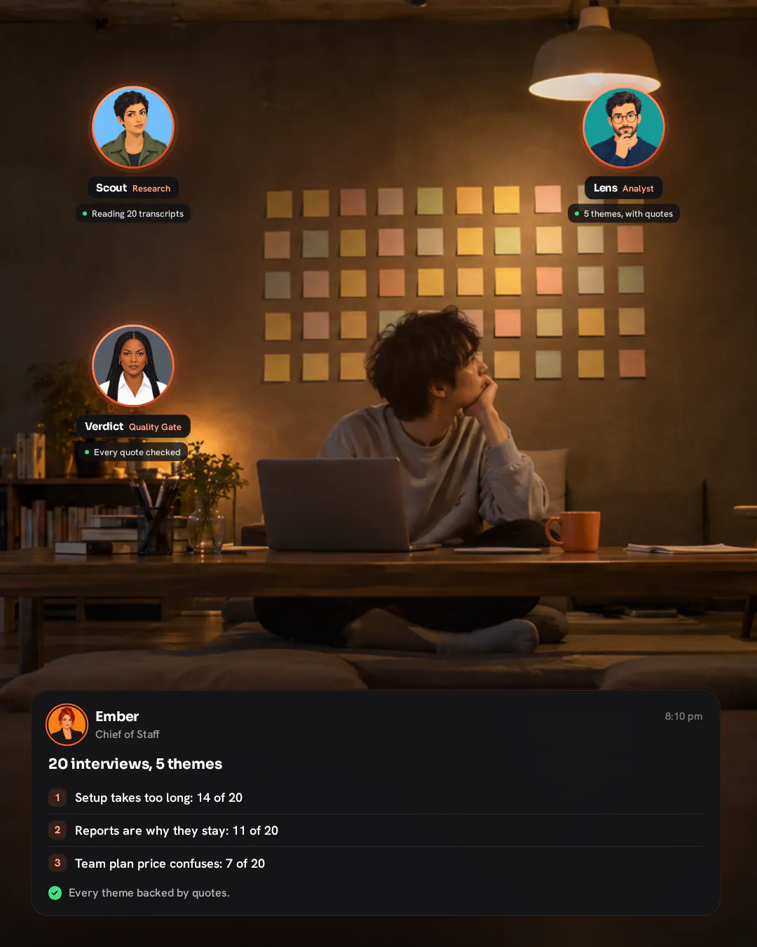A young product designer sitting cross-legged at a low table in the evening, looking at a wall of blank sticky notes.