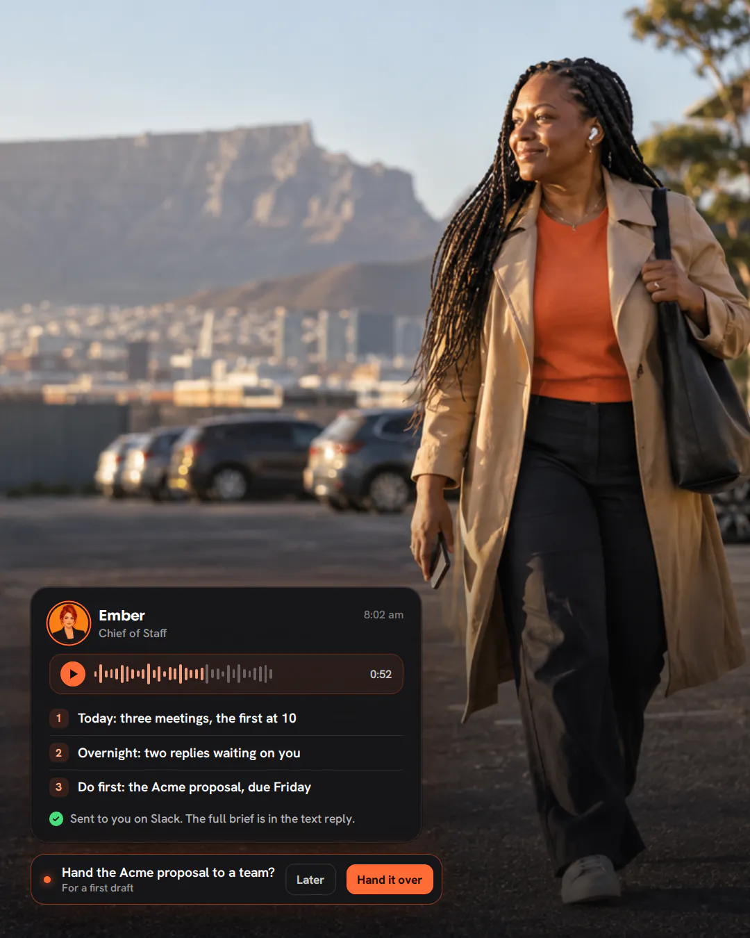 An events company owner with earbuds walking across a car park in the morning sun, listening with a small smile.